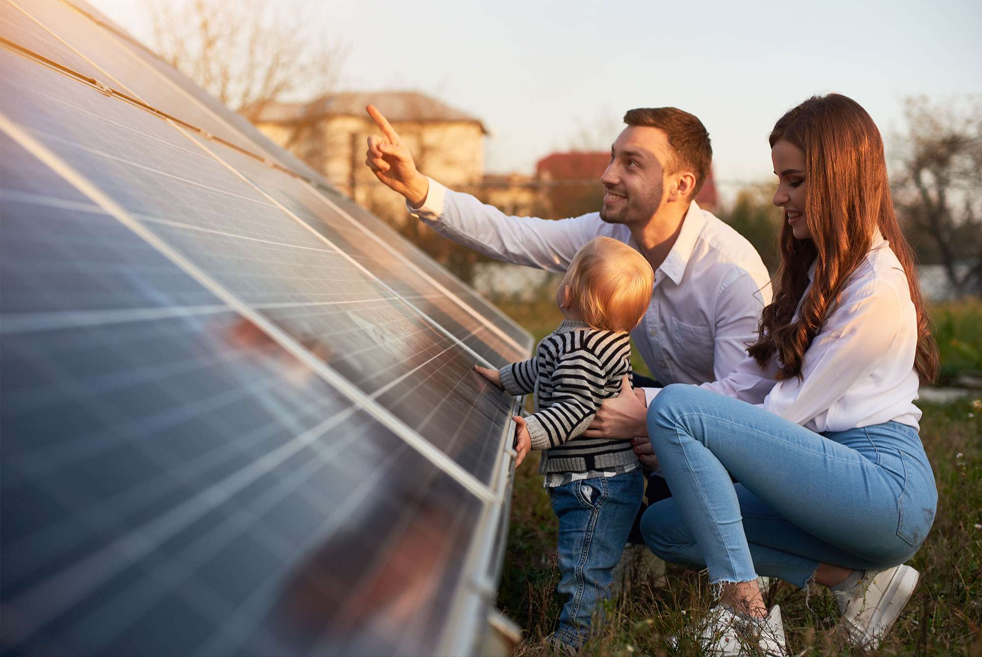 Eltern mit Ihrem Kind vor einer Photovoltaikanlagen